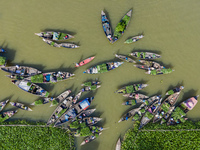 An aerial view shows traders selling fruits and vegetables from boats at Boithakata floating market on the Belua River in Pirojpur, Barisal,...