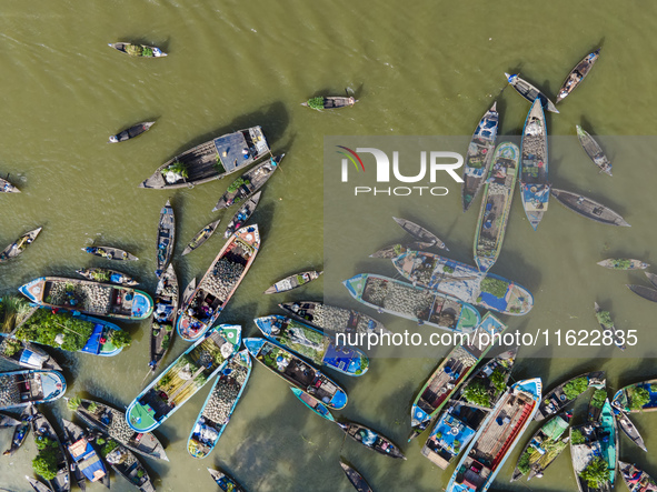 An aerial view shows traders selling fruits and vegetables from boats at Boithakata floating market on the Belua River in Pirojpur, Barisal,...