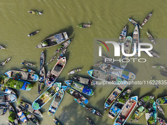 An aerial view shows traders selling fruits and vegetables from boats at Boithakata floating market on the Belua River in Pirojpur, Barisal,...