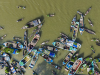 An aerial view shows traders selling fruits and vegetables from boats at Boithakata floating market on the Belua River in Pirojpur, Barisal,...