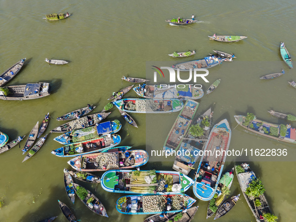 An aerial view shows traders selling fruits and vegetables from boats at Boithakata floating market on the Belua River in Pirojpur, Barisal,...