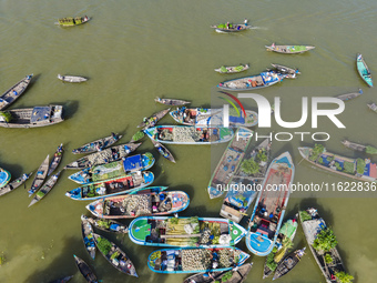 An aerial view shows traders selling fruits and vegetables from boats at Boithakata floating market on the Belua River in Pirojpur, Barisal,...