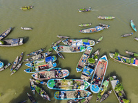 An aerial view shows traders selling fruits and vegetables from boats at Boithakata floating market on the Belua River in Pirojpur, Barisal,...