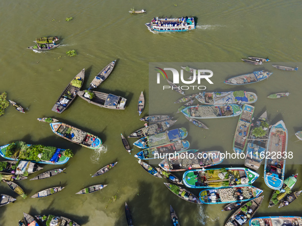 An aerial view shows traders selling fruits and vegetables from boats at Boithakata floating market on the Belua River in Pirojpur, Barisal,...