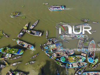 An aerial view shows traders selling fruits and vegetables from boats at Boithakata floating market on the Belua River in Pirojpur, Barisal,...