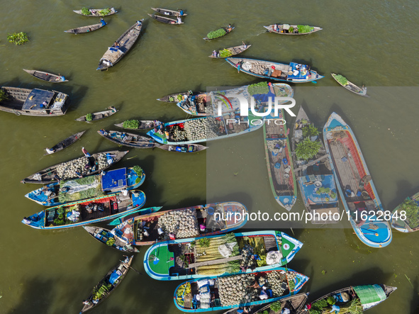 An aerial view shows traders selling fruits and vegetables from boats at Boithakata floating market on the Belua River in Pirojpur, Barisal,...