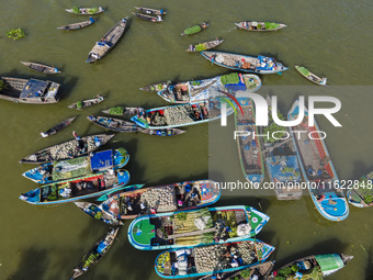 An aerial view shows traders selling fruits and vegetables from boats at Boithakata floating market on the Belua River in Pirojpur, Barisal,...