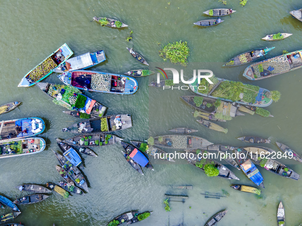 An aerial view shows traders selling fruits and vegetables from boats at Boithakata floating market on the Belua River in Pirojpur, Barisal,...