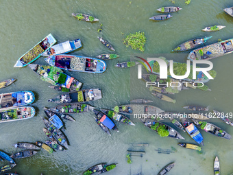 An aerial view shows traders selling fruits and vegetables from boats at Boithakata floating market on the Belua River in Pirojpur, Barisal,...