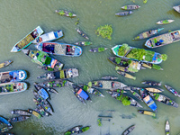 An aerial view shows traders selling fruits and vegetables from boats at Boithakata floating market on the Belua River in Pirojpur, Barisal,...