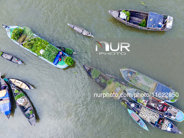 An aerial view shows traders selling fruits and vegetables from boats at Boithakata floating market on the Belua River in Pirojpur, Barisal,...