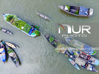 An aerial view shows traders selling fruits and vegetables from boats at Boithakata floating market on the Belua River in Pirojpur, Barisal,...