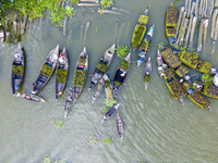 An aerial view shows traders selling fruits and vegetables from boats at Boithakata floating market on the Belua River in Pirojpur, Barisal,...