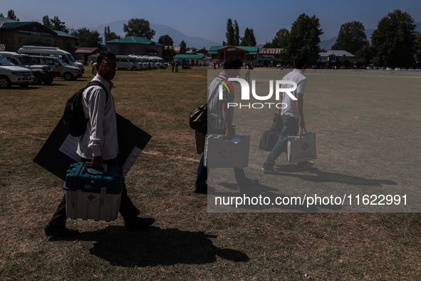 Kashmiri polling officials carry sealed Electronic Voting Machines (EVM) and Voter Verifiable Paper Audit Trail (VVPAT) machines as they mov...