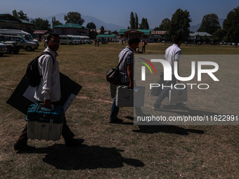 Kashmiri polling officials carry sealed Electronic Voting Machines (EVM) and Voter Verifiable Paper Audit Trail (VVPAT) machines as they mov...