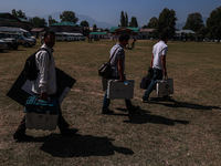 Kashmiri polling officials carry sealed Electronic Voting Machines (EVM) and Voter Verifiable Paper Audit Trail (VVPAT) machines as they mov...