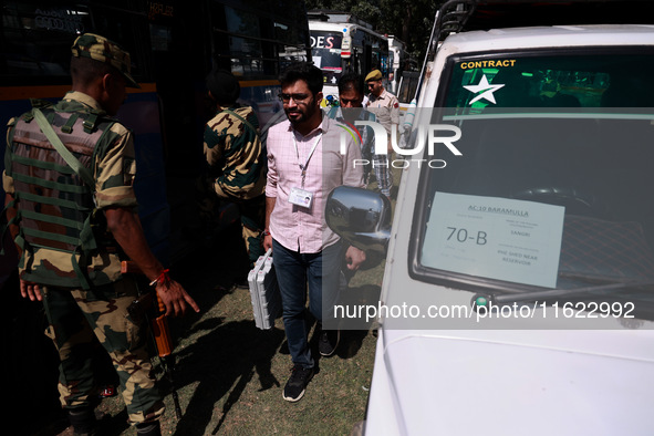 Kashmiri polling officials carry sealed Electronic Voting Machines (EVM) and Voter Verifiable Paper Audit Trail (VVPAT) machines as they mov...