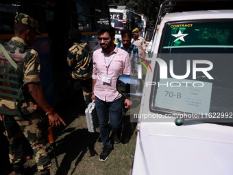 Kashmiri polling officials carry sealed Electronic Voting Machines (EVM) and Voter Verifiable Paper Audit Trail (VVPAT) machines as they mov...