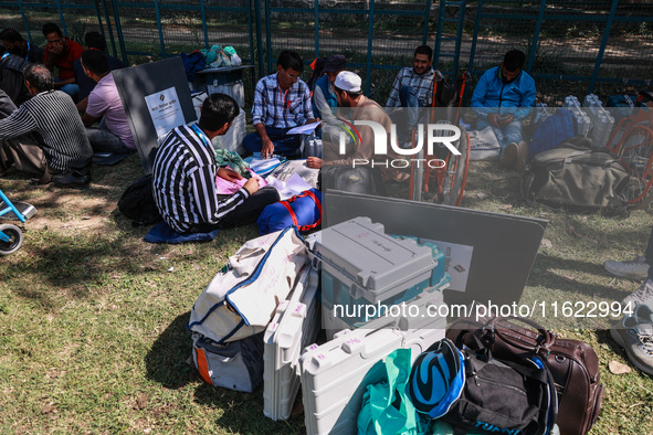 Kashmiri polling officials carry sealed Electronic Voting Machines (EVM) and Voter Verifiable Paper Audit Trail (VVPAT) machines as they mov...