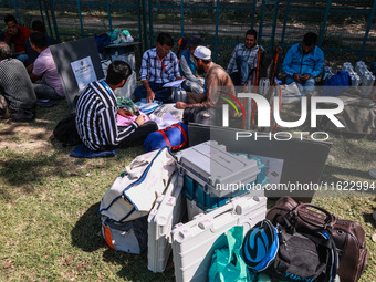 Kashmiri polling officials carry sealed Electronic Voting Machines (EVM) and Voter Verifiable Paper Audit Trail (VVPAT) machines as they mov...