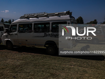 A driver rests behind a van as Kashmiri polling officials carry sealed Electronic Voting Machines (EVM) and Voter Verifiable Paper Audit Tra...