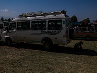 A driver rests behind a van as Kashmiri polling officials carry sealed Electronic Voting Machines (EVM) and Voter Verifiable Paper Audit Tra...