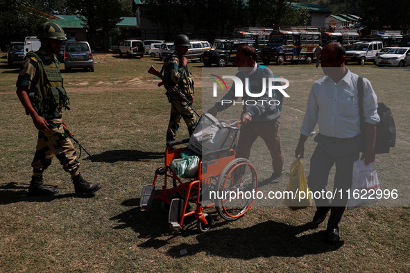 Kashmiri polling officials carry sealed Electronic Voting Machines (EVM) and Voter Verifiable Paper Audit Trail (VVPAT) machines as they mov...