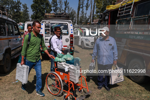 Kashmiri polling officials carry sealed Electronic Voting Machines (EVM) and Voter Verifiable Paper Audit Trail (VVPAT) machines as they mov...