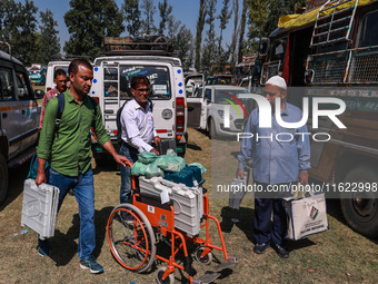 Kashmiri polling officials carry sealed Electronic Voting Machines (EVM) and Voter Verifiable Paper Audit Trail (VVPAT) machines as they mov...