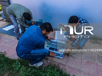 Kashmiri polling officials carry sealed Electronic Voting Machines (EVM) and Voter Verifiable Paper Audit Trail (VVPAT) machines as they mov...