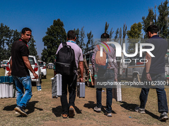 Kashmiri polling officials carry sealed Electronic Voting Machines (EVM) and Voter Verifiable Paper Audit Trail (VVPAT) machines as they mov...