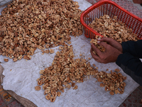 A vendor sorts walnut seeds as he waits for customers in Handwara, Jammu and Kashmir, India, on September 28, 2024. (