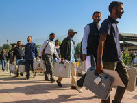 Polling officials carry electronic voting machines (EVM) at a distribution center in Sumbal area of Bandipora district, North of Srinagar, o...