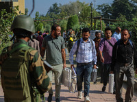 An Indian paramilitary soldier stands guard as polling officials carry electronic voting machines (EVM) at a distribution center in the Sumb...