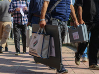 Polling officials carry electronic voting machines (EVM) at a distribution center in Sumbal area of Bandipora district, North of Srinagar, o...