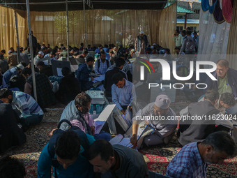 Polling officials with electronic voting machines (EVM) gather at a distribution center in Sumbal Area of Bandipora District, North of Srina...