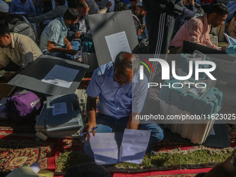 Polling officials with electronic voting machines (EVM) gather at a distribution center in Sumbal Area of Bandipora District, North of Srina...