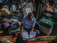 Polling officials with electronic voting machines (EVM) gather at a distribution center in Sumbal Area of Bandipora District, North of Srina...