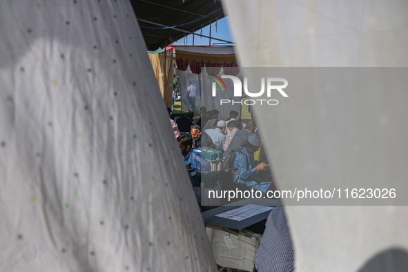 Polling officials with electronic voting machines (EVM) gather at a distribution center in Sumbal Area of Bandipora District, North of Srina...