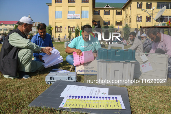 Polling officials with electronic voting machines (EVM) gather at a distribution center in Sumbal Area of Bandipora District, North of Srina...