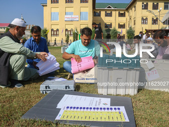 Polling officials with electronic voting machines (EVM) gather at a distribution center in Sumbal Area of Bandipora District, North of Srina...