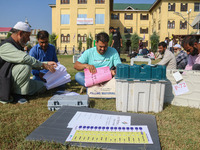 Polling officials with electronic voting machines (EVM) gather at a distribution center in Sumbal Area of Bandipora District, North of Srina...