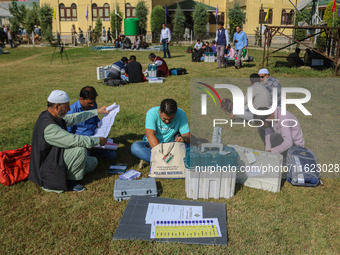 Polling officials with electronic voting machines (EVM) gather at a distribution center in Sumbal Area of Bandipora District, North of Srina...