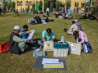 Polling officials with electronic voting machines (EVM) gather at a distribution center in Sumbal Area of Bandipora District, North of Srina...