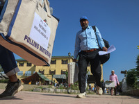 Polling officials carry electronic voting machines (EVM) at a distribution center in Sumbal area of Bandipora district, North of Srinagar, o...