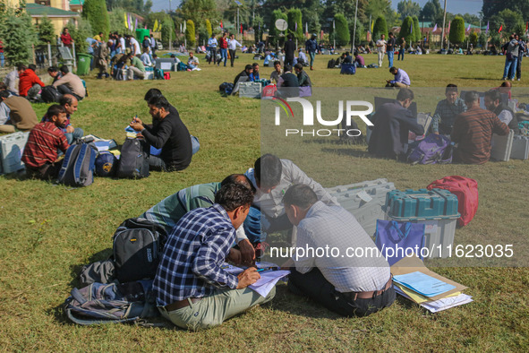 Polling officials with electronic voting machines (EVM) gather at a distribution center in Sumbal Area of Bandipora District, North of Srina...