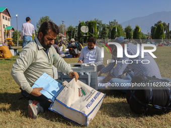 Polling officials with electronic voting machines (EVM) gather at a distribution center in Sumbal Area of Bandipora District, North of Srina...