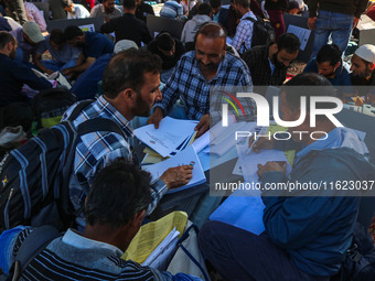 Polling officials with electronic voting machines (EVM) gather at a distribution center in Sumbal Area of Bandipora District, North of Srina...