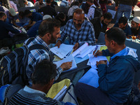 Polling officials with electronic voting machines (EVM) gather at a distribution center in Sumbal Area of Bandipora District, North of Srina...