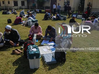 Polling officials with electronic voting machines (EVM) gather at a distribution center in Sumbal Area of Bandipora District, North of Srina...